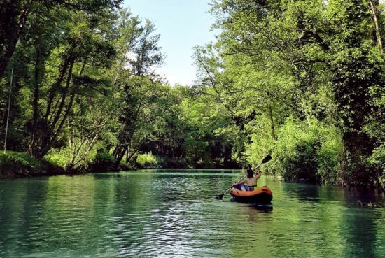 Photo d’un kayak naviguant sur la rivière Aveyron, entouré de paysages verdoyants et d’une nature préservée